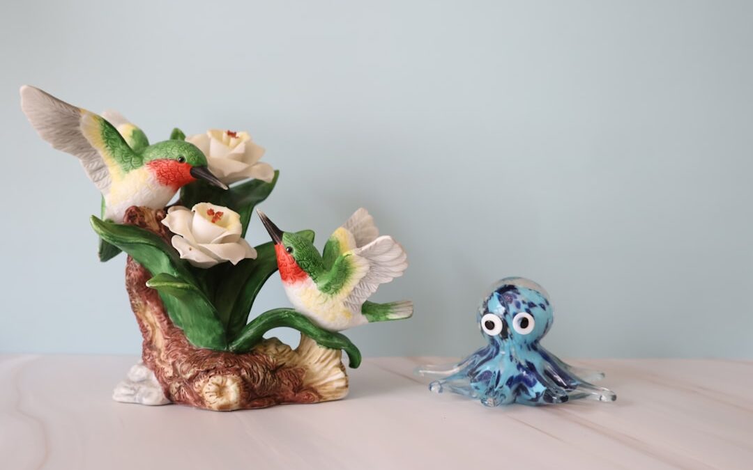A ceramic hummingbird sculpture paired with a blue glass octopus figurine
